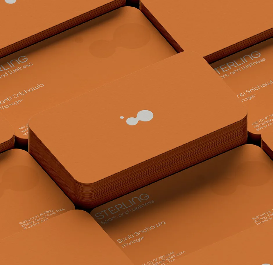 Stacks of orange Sterling business cards with the white dot symbol